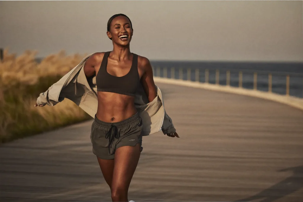 Woman enjoying a comfortable morning jog along the coast after breast reduction surgery near Dubai.