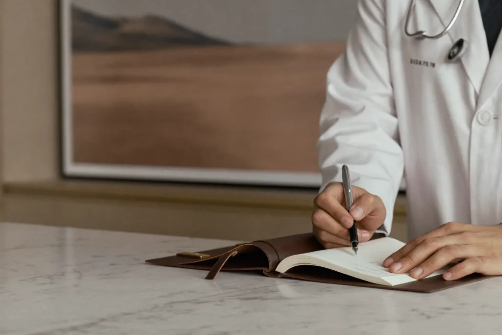 Close-up of a surgeon's hands reviewing a mommy makeover surgical plan in a Dubai clinic.